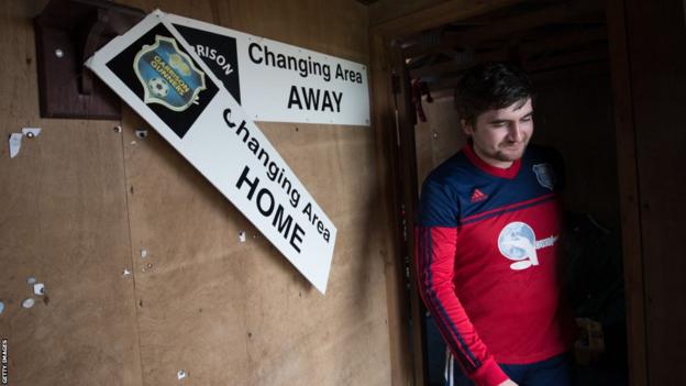 A player comes out of the dressing room at Garrison Field