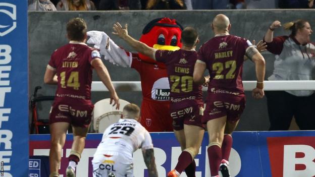 Mikey Lewis (centre) celebrates his try