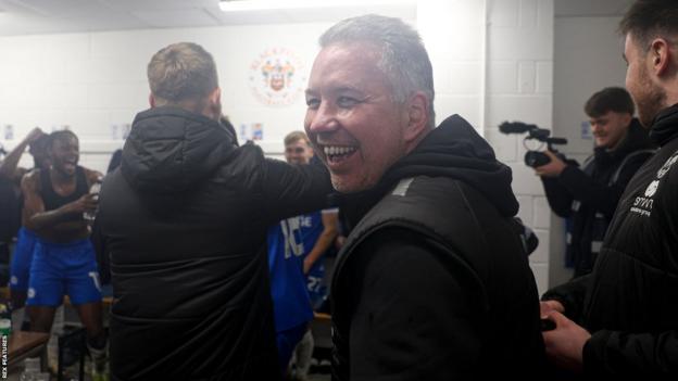 Peterborough United boss Darren Ferguson celebrates in the changing room with his players after reaching Wembley in the EFL Trophy