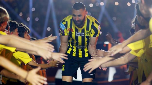 Karim Benzema greets mascots during his unveiling at Al-Riyadh