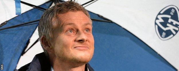 Molde head coach Ole Gunnar Solskjaer shelters from the rain