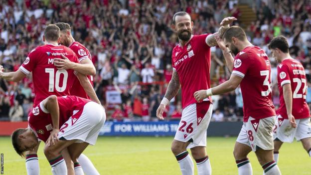 Steven Fletcher and Wrexham team-mates celebrate a gpal at the Racecourse