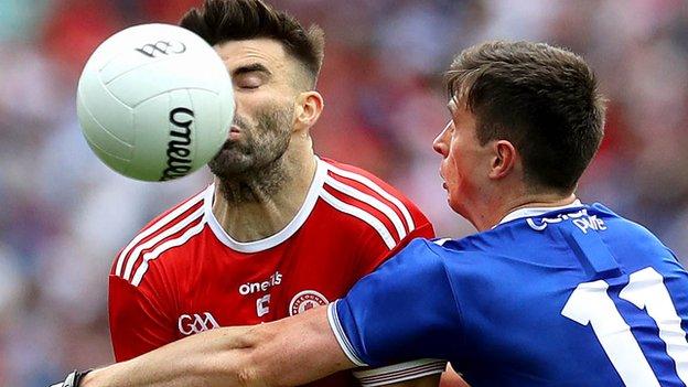 Tyrone defender Tiarnan McCann feels the impact of a strong challenge from Shane Corey at Croke Park