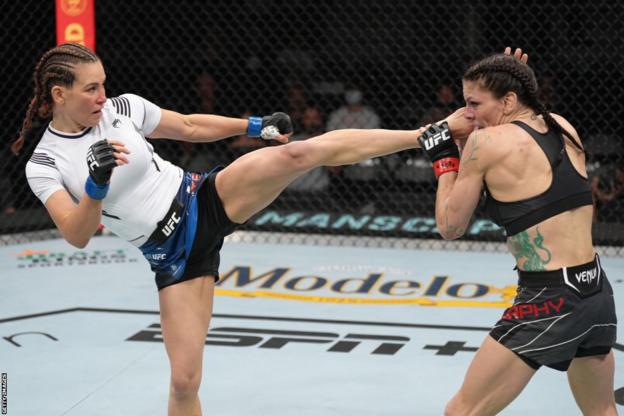 Miesha Tate (left) throws a head kick at Lauren Murphy (right)
