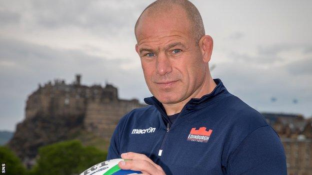 Richard Cockerill poses in front of a backdrop of Edinburgh Castle