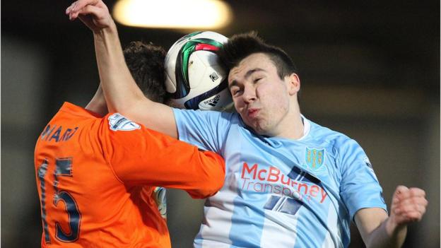Linfield goalscorer Sean Ward and Ballymena substitute Matthew Ferguson jump for a high ball at the Showgrounds