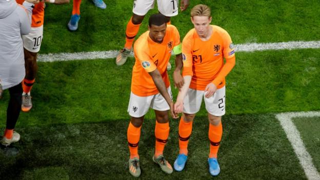Wijnaldum and De Jong pointing to the colour of their skin