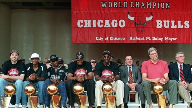 Chicago Bulls' players pose with the six NBA titles they won in the 1990s.