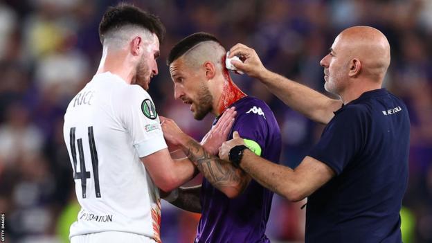 Cristiano Biraghi of Fiorentina receives treatment for a wound to the head after appearing to be struck by an object