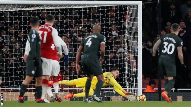 Manchester City goalkeeper Ederson makes a save during a match against Arsenal