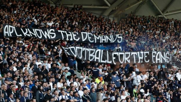 Melbourne Victory fans hold banners against APL