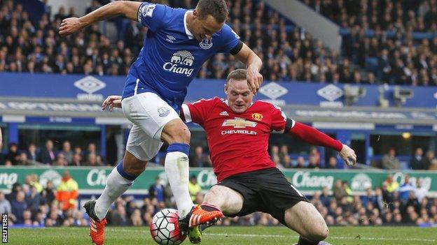 Everton captain Phil Jagielka tussles with Manchester United's Wayne Rooney