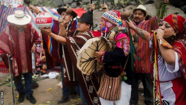 Peruvian shamans perform spiritual rituals with rattles, smoke and flowers