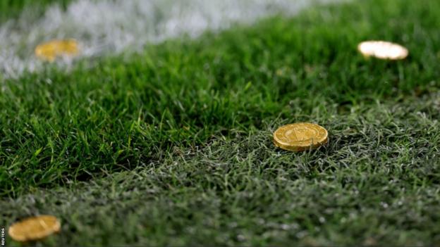 Chocolate gold coins thrown onto the pitch during the match between Dortmund and Freiburg