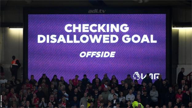 A big screen shows a VAR decision being checked