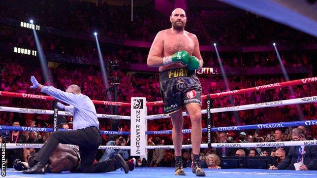 Tyson Fury walks back to his corner after knocking down Deontay Wilder