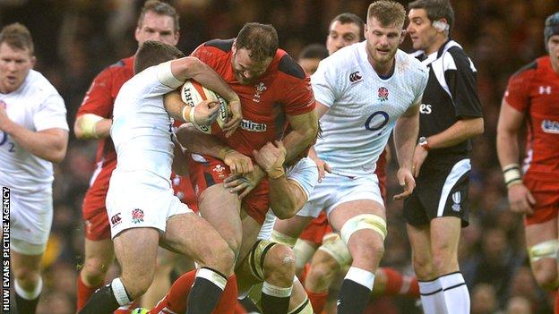 Jamie Roberts of Wales is tackled by George Ford and Ben Youngs