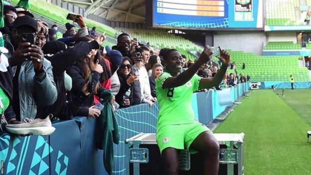 Asisat taking a selfie with Nigerian fans after the World Cup match against Canada
