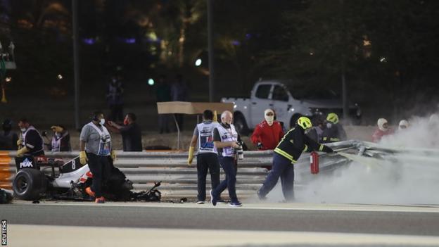 Marshals attend to Romain Grosjean's car