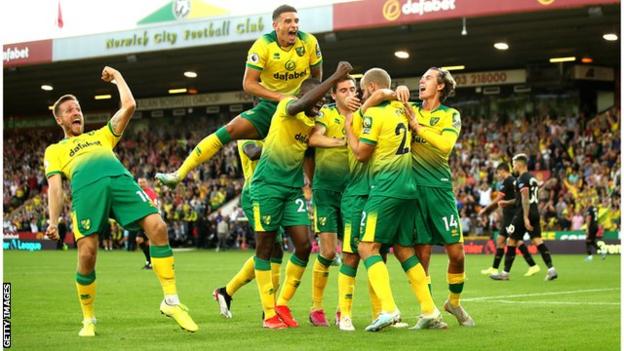 Norwich City's players celebrate scoring against Manchester City in 2019