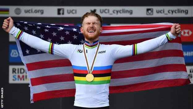 Quinn Simmons holds up the US flag on the podium after winning the road race at the World Junior Championships in 2019