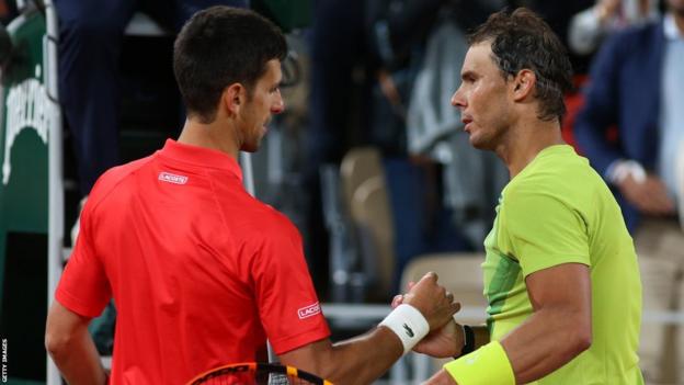 Novak Djokovic and Rafael Nadal meet at the net at the 2022 French Open