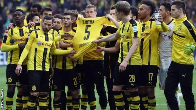 Borussia Dortmund players hold the shirt of their injured team mate Marc Bartra after winning at home on Saturday