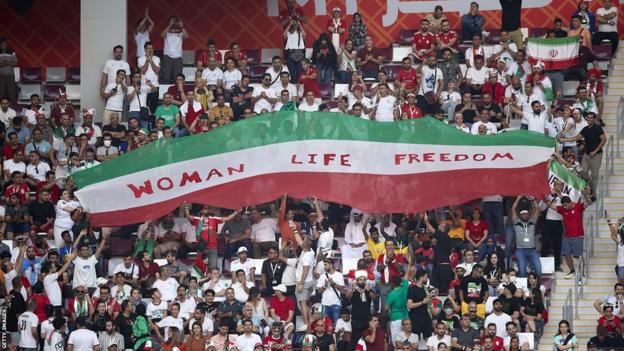 A Women Life Freedom banner is unveiled during the Iran v England game