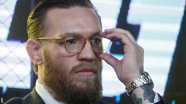 Conor McGregor touches his spectacles