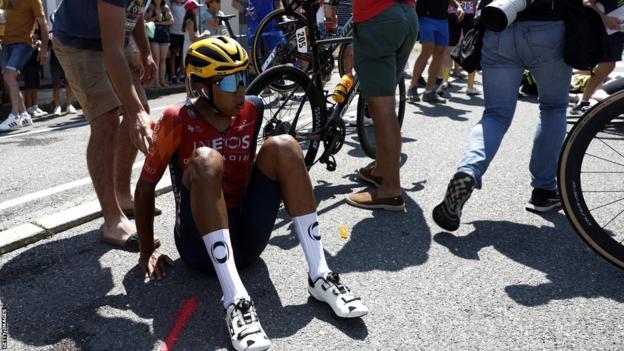 Egan Bernal sitting on the ground after coming off his bike