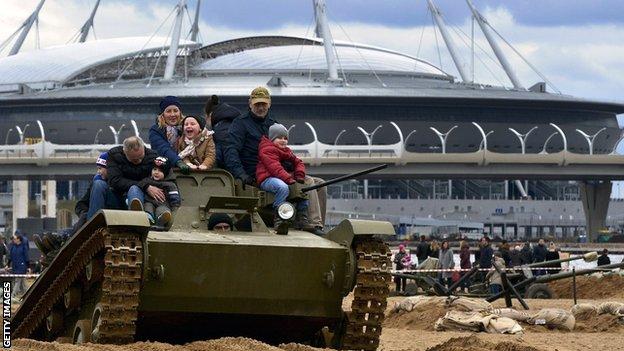 Fans pose on a tank outside the Zenit Arena