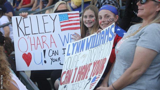 Fans of Kelley O'Hara and Lynn Williams hold signs
