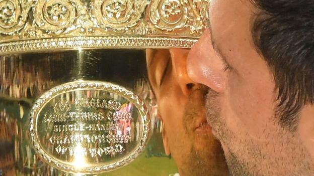 Tennis - Wimbledon - All England Lawn Tennis and Croquet Club, London, Britain - July 14, 2019 General view of the reflection on the trophy of Serbia"s Novak Djokovic kissing it as he celebrates winning the final against Switzerland"s Roger Federer REUTERS/Toby Melville TPX IMAGES OF THE DAY