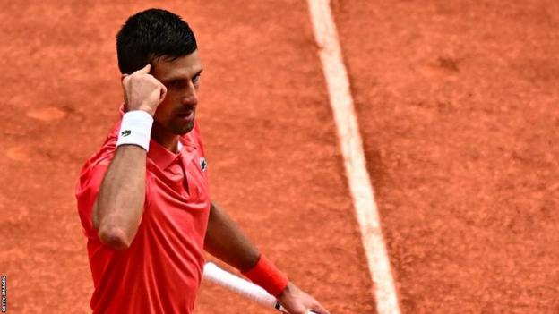 Novak Djokovic points to his temple astatine  the French Open