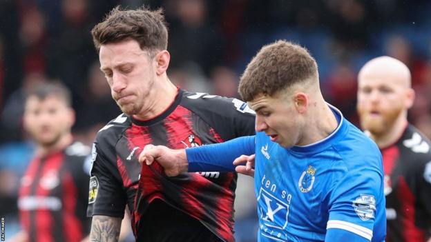 Jordan Forsythe and Ethan McGee vie for possession at Mourneview Park