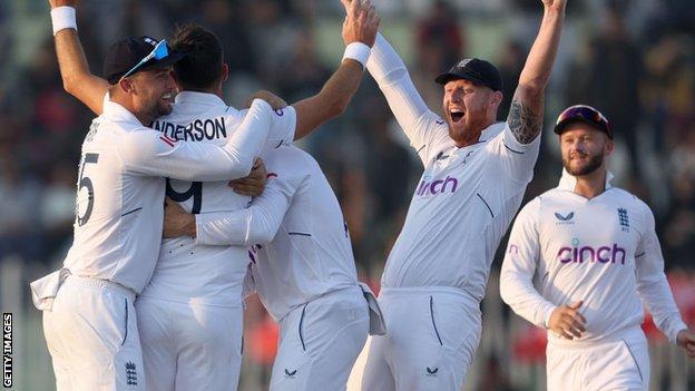 England's James Anderson and Ben Stokes celebrate with other players