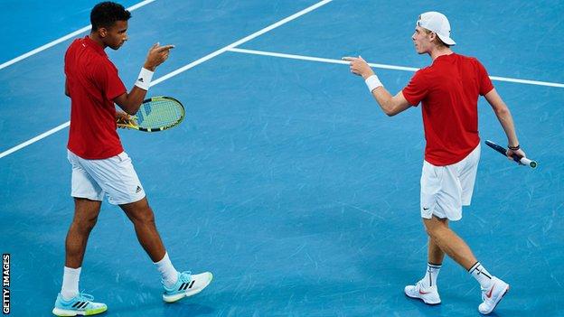 Felix Auger-Aliassime and Denis Shapovalov point at each other