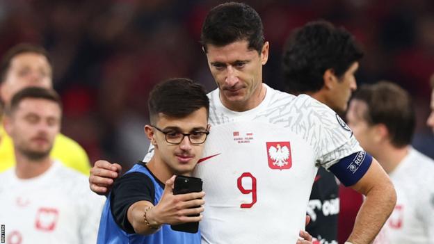 Robert Lewandowski poses for a selfie with a fan