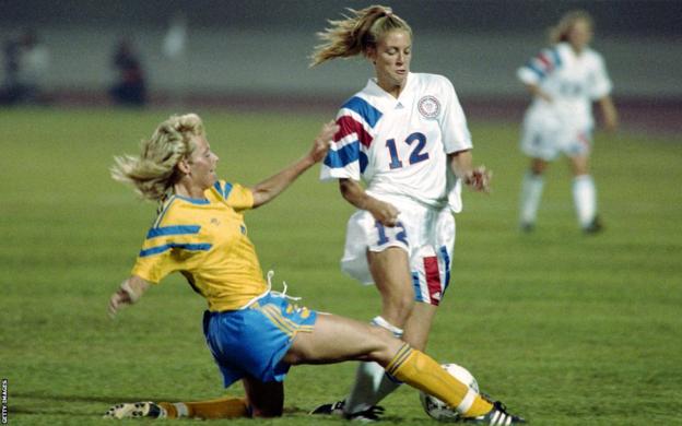 American striker Carin Jennings (12) tries to avoid the tackle of Swede Anette Hansson (3) during their Group B opening match in the inaugural match in Guangzhou stadium on November 17, 1991,