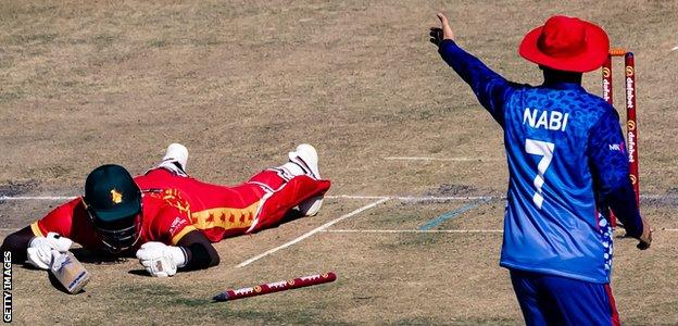 Zimbabwe's Luke Jongwe lies on the pitch after being run out against Afghanistan