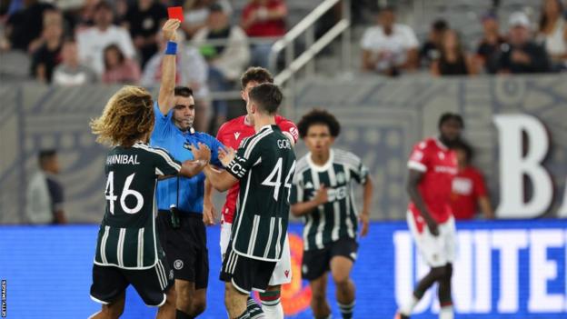 Manchester United's Dan Gore is shown a red card