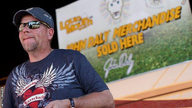 John Daly sells merchandise to fans on Washington Road outside his mobile home prior to the 2010 Masters Tournament at Augusta National Golf Club on April 5, 2010