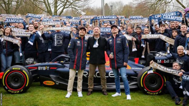 Red Bull's Sergio Perez, Christian Horner and Max Verstappen with team staff holding up scarves