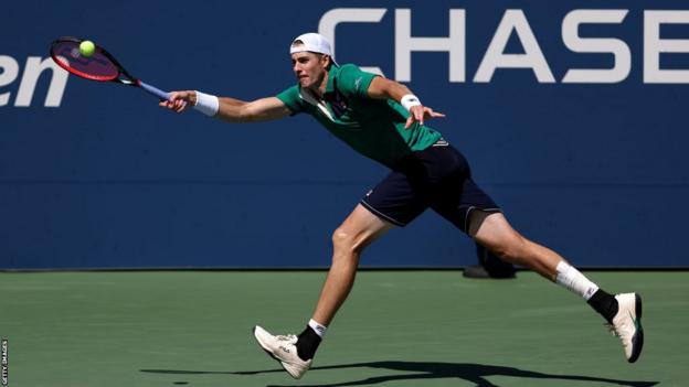 John Isner takes a shot in his final US Open appearance