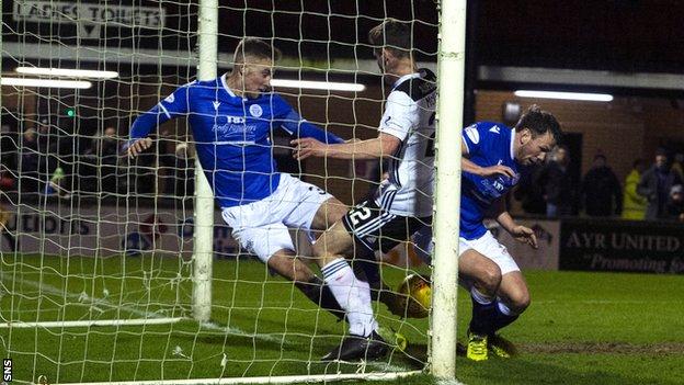 Queen of the South's Kevin Holt clears an effort from Ayr’s Mark McKenzie