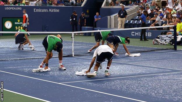 Tournament staff wipe the court at the US Open