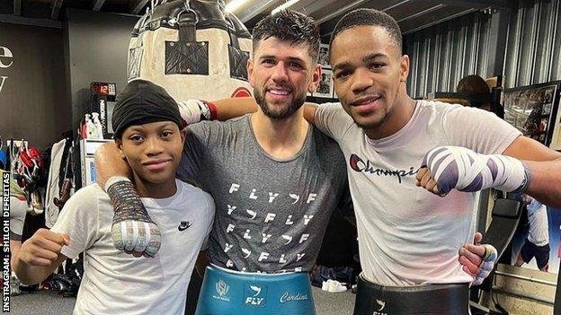 Defreitas and younger brother Yash pose with sparring partner Joe Cordina