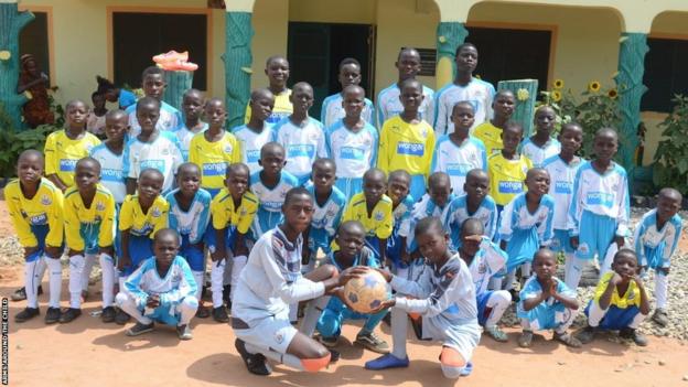 Children of the orphanage in football outfit posing for a group picture