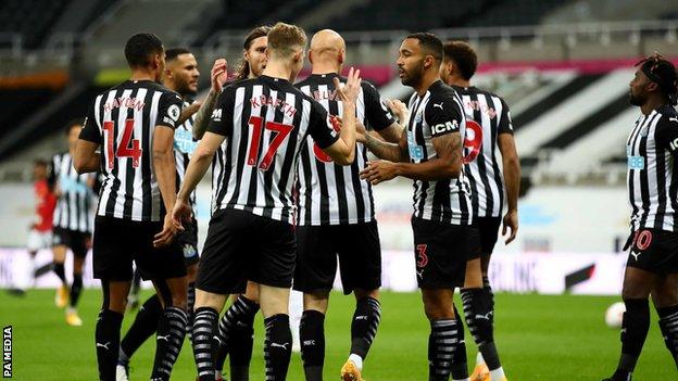 Newcastle players celebrate after Luke Shaw put the ball into his own net