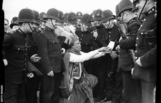Monolulu pictured revealing tips to a large group of police officers at Epsom racecourse, 1938